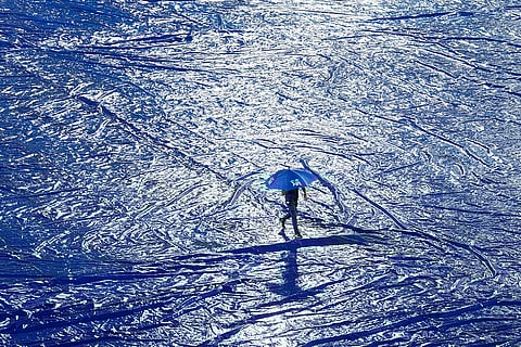 Groundsmen cover the pitch due to rains